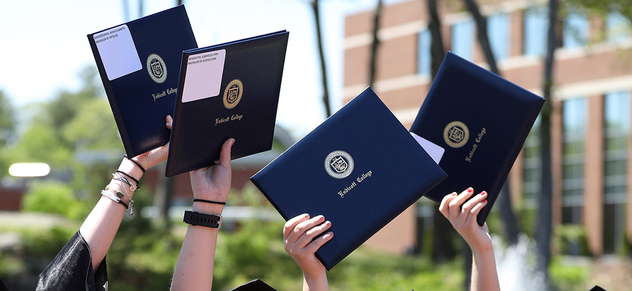 Diplomas raised in the air.