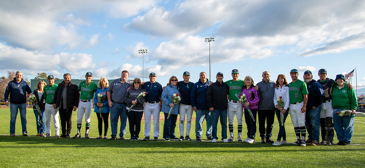 Families and senior baseball student-athletes pose for a photo.