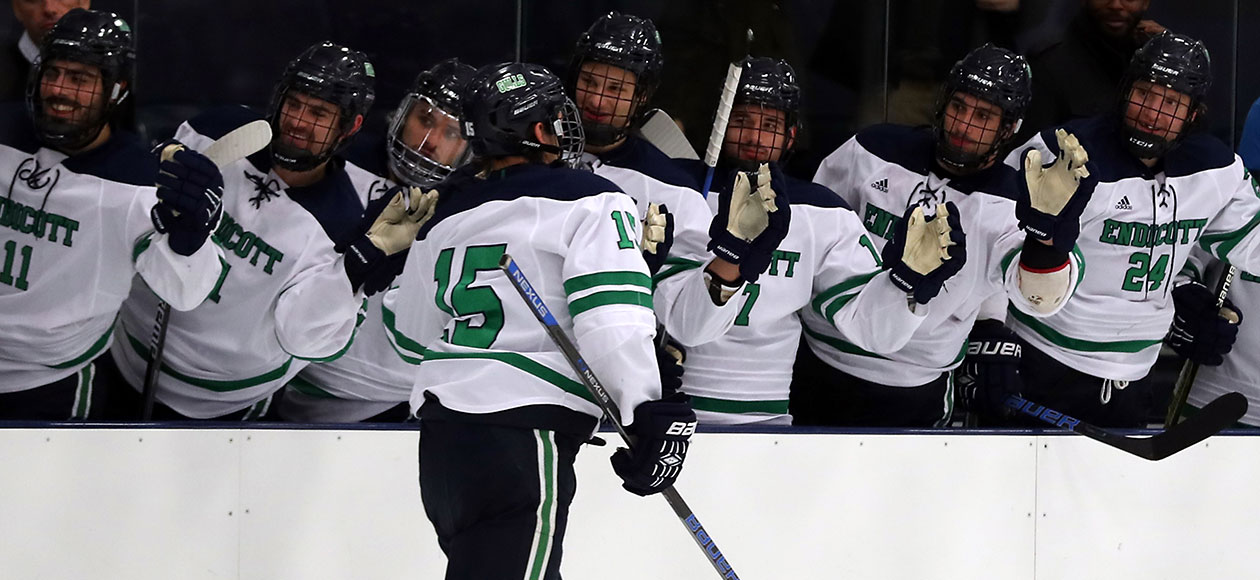 Josh Bowes skates by the Endicott men's ice hockey bench and high-fives his teammates.
