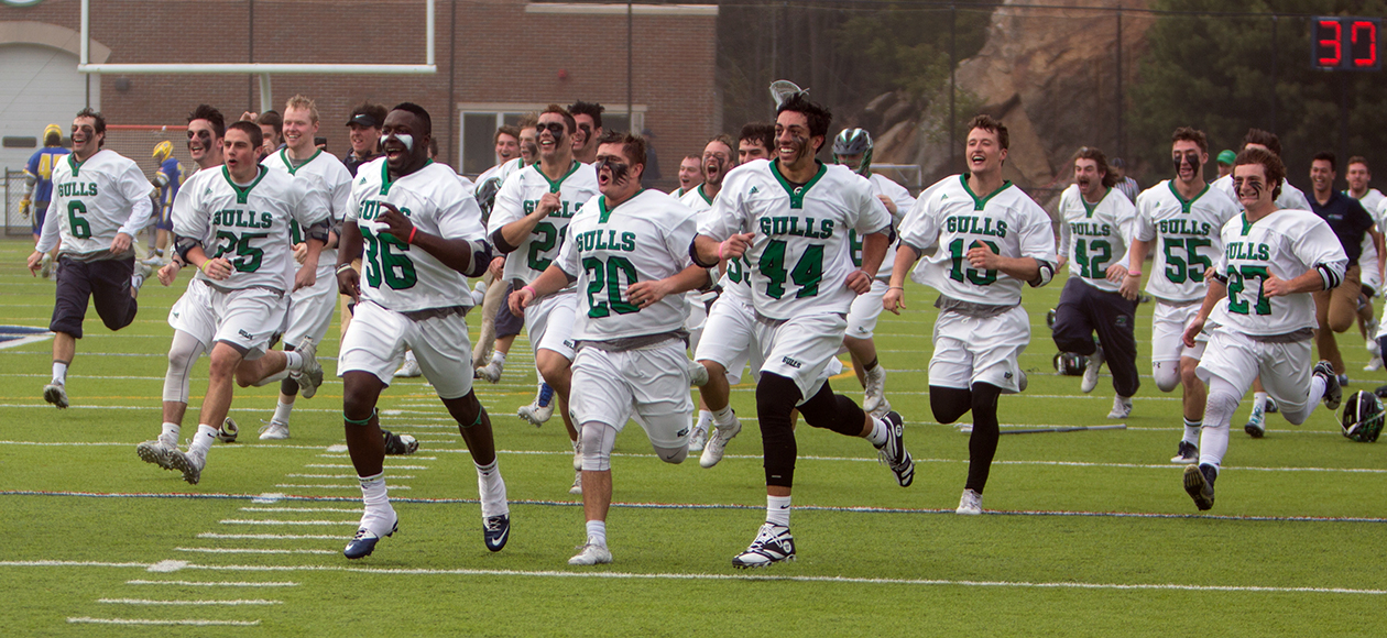 Members of the men's lacrosse team rush the field after winning the 2017 CCC Championship.