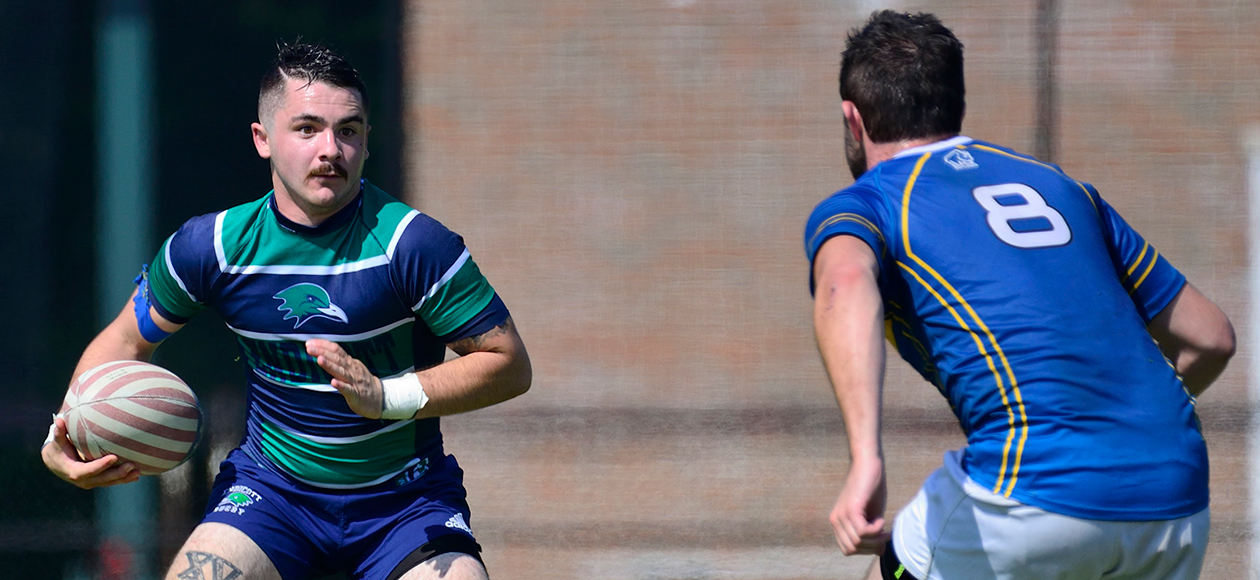 A men's rugby student-athlete evades a defender.