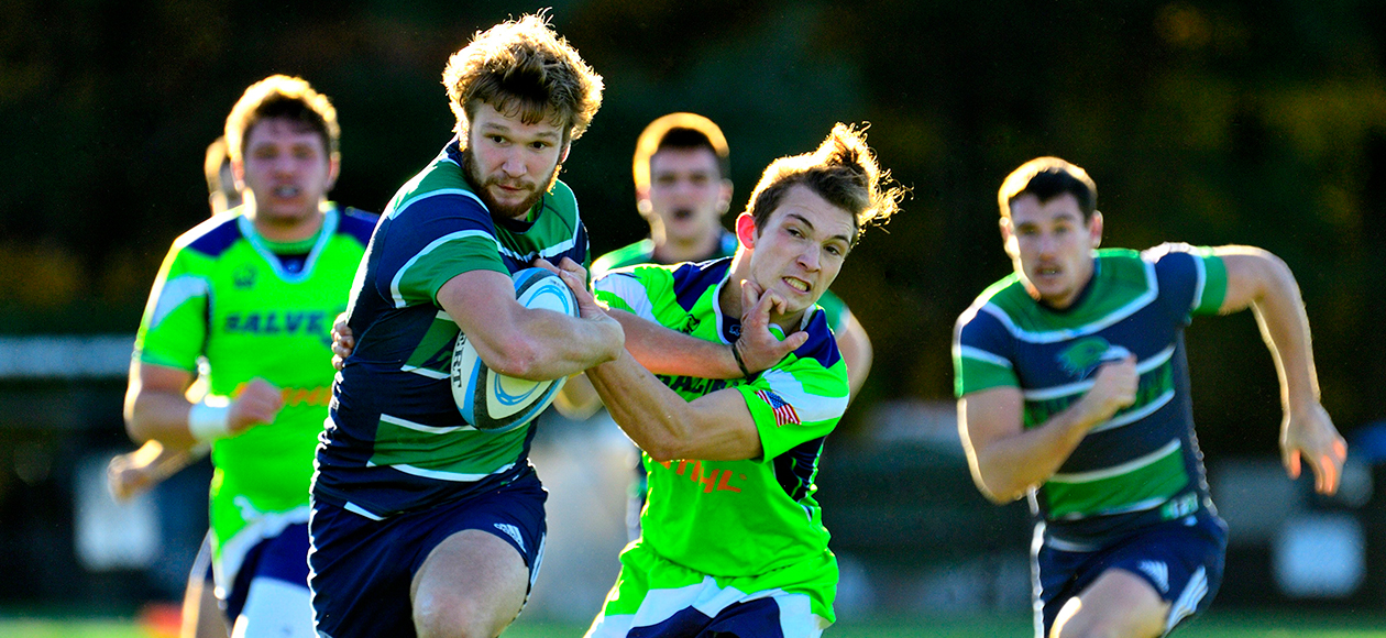 A men's rugby student-athlete stiff arms a Salve Regina student-athlete.