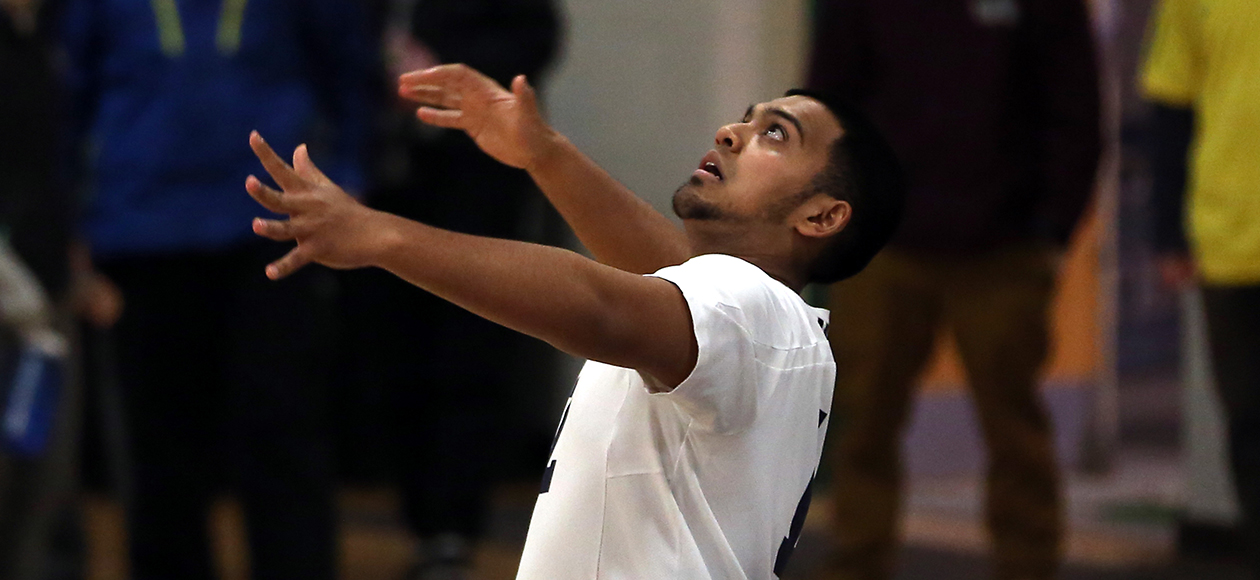 Amar Patel attempts to serve a volleyball.
