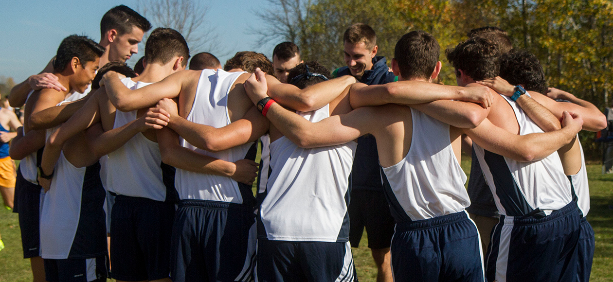 Men's cross country team huddles before a race.