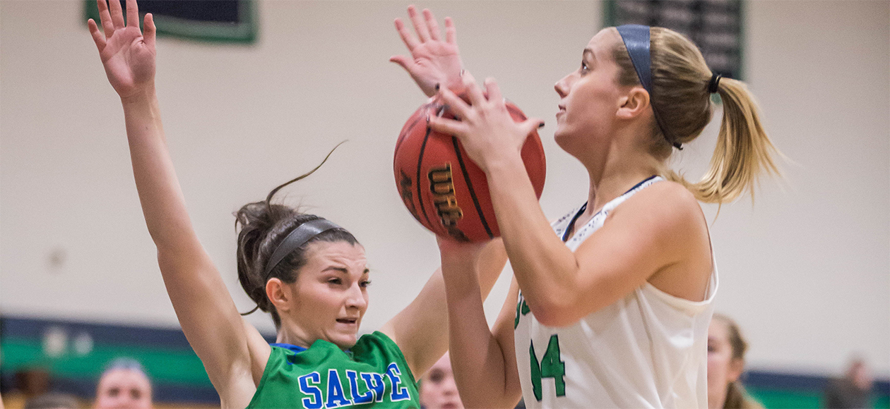 Junior guard Hannah Kiernan is charged with an offensive foul as she goes up for a layup against Salve Regina.