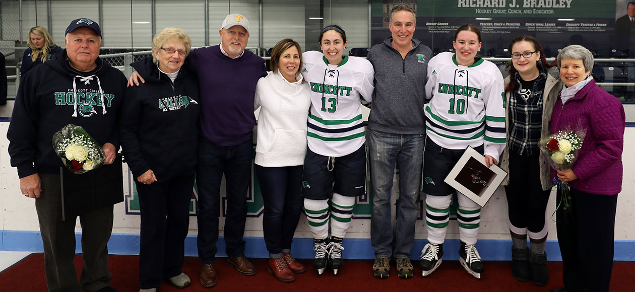 Endicott women's ice hockey seniors post for a photo with their families.