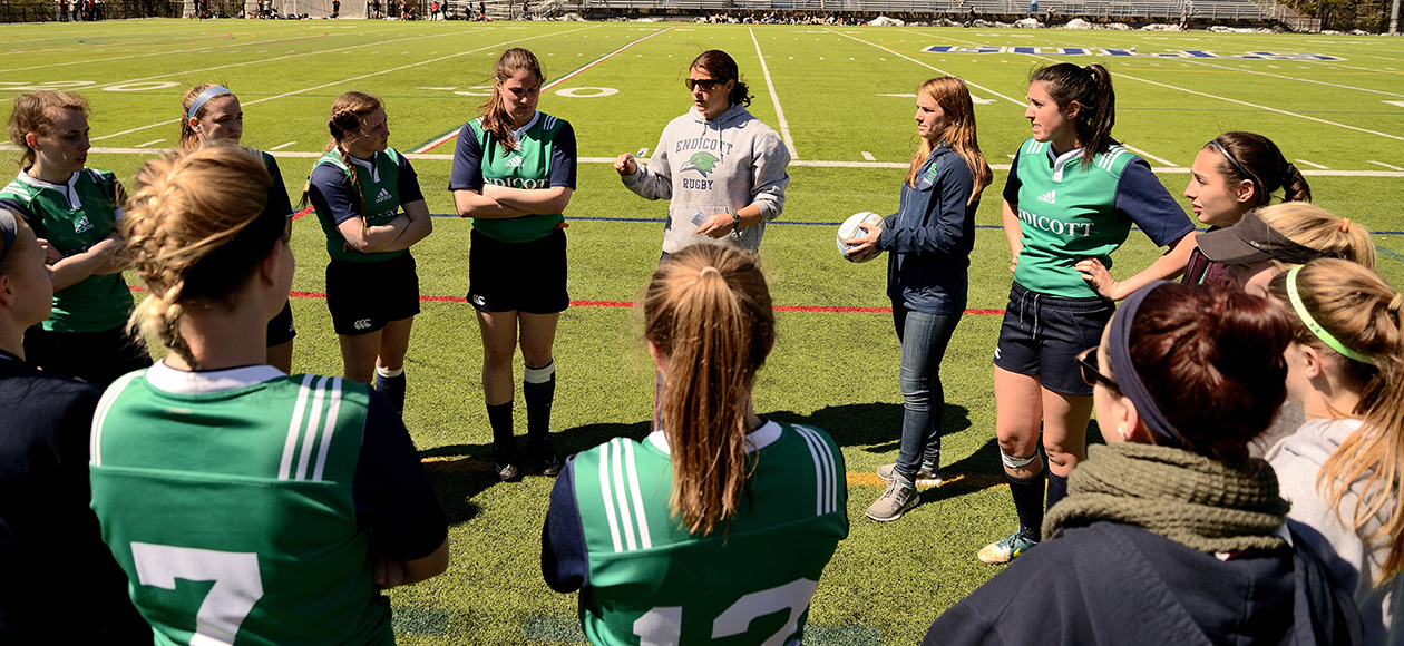 Women's club rugby huddles before a contest.
