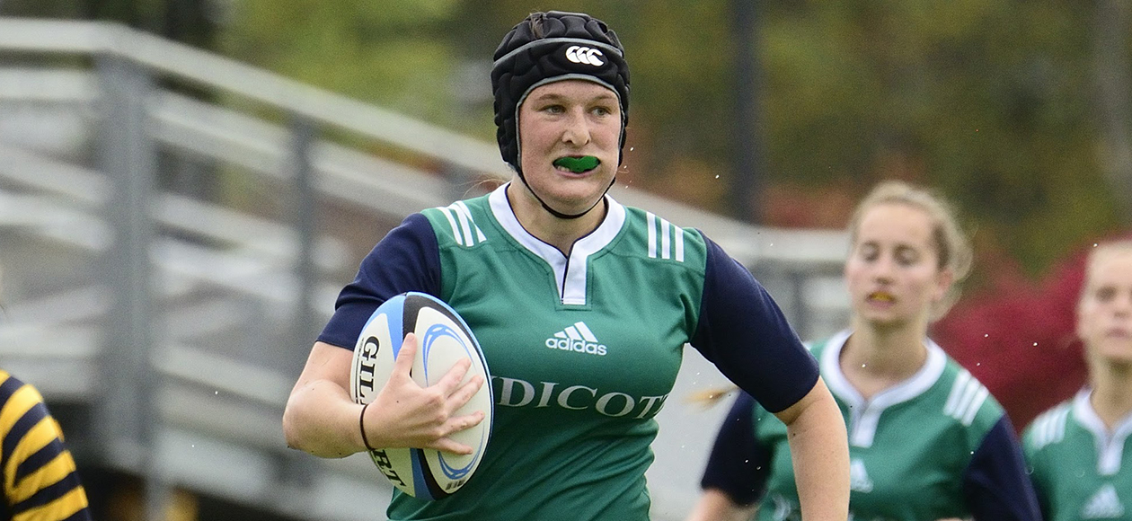A women's rugby student-athlete runs with the ball.