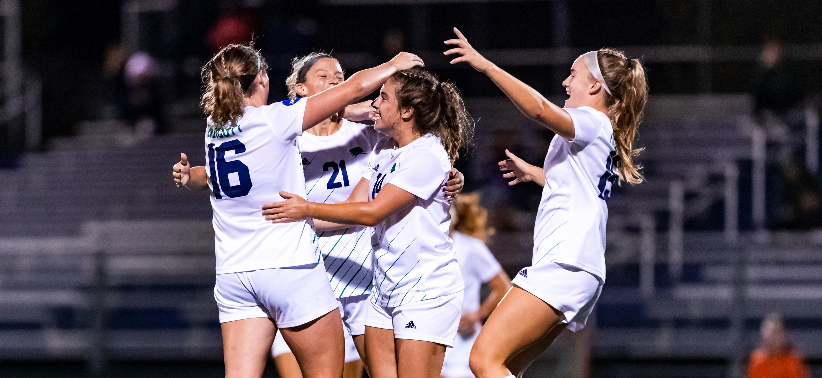 Members of the women's soccer team celebrate a goal against Wheaton on Wednesday night.