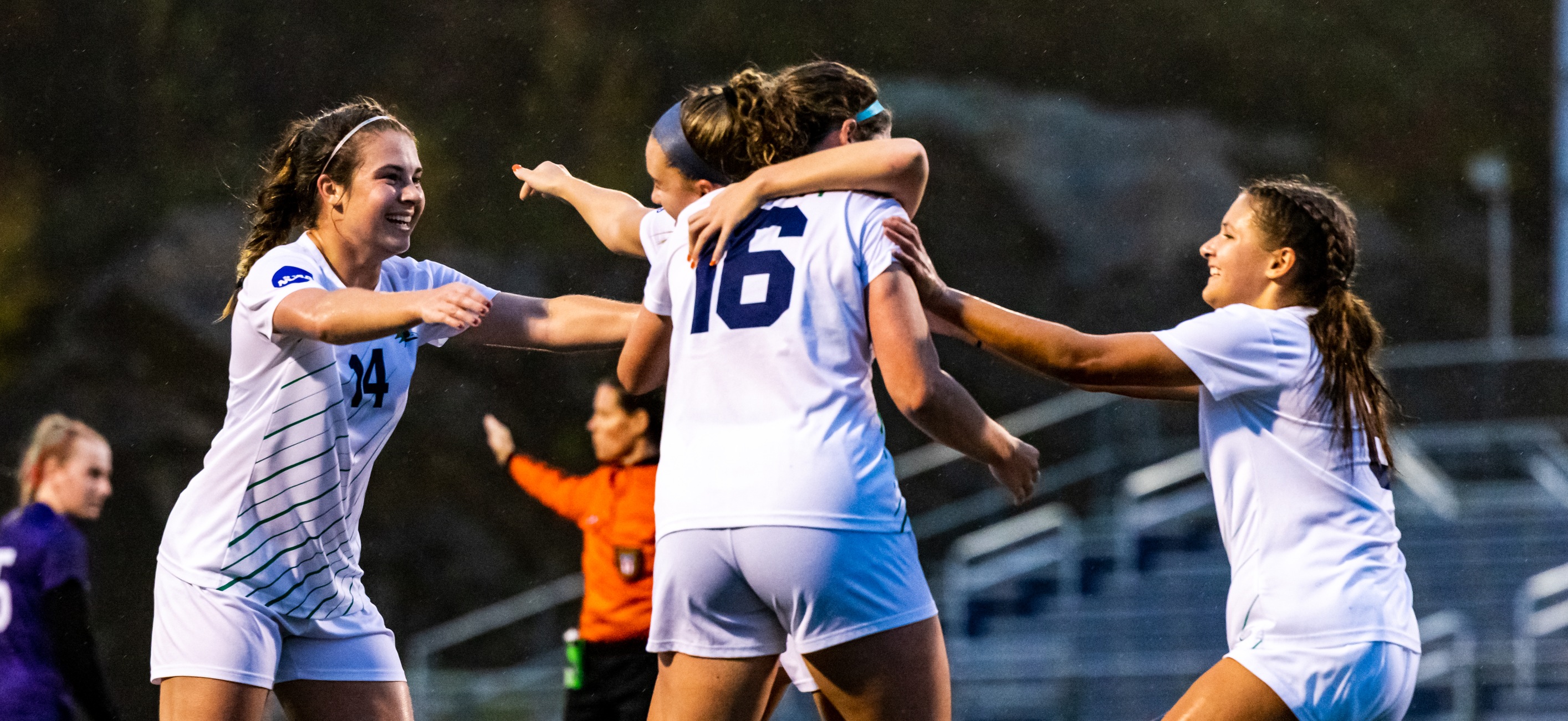 Members of the women's soccer team celebrate a goal by Madeline Mucher.