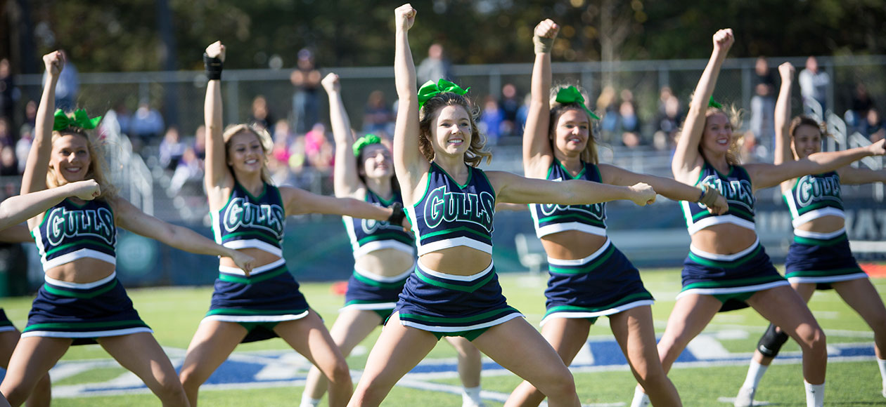 The cheer team cheers at halftime of a game.