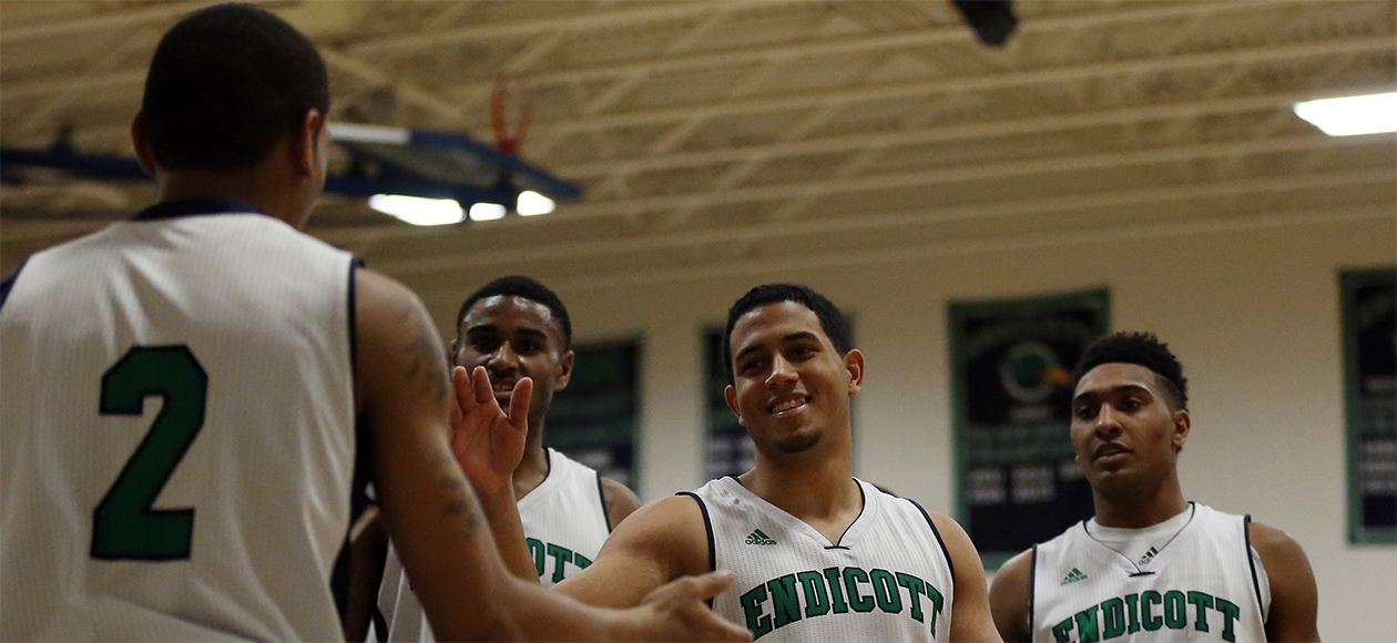 The Endicott men's basketball team gives high fives to each other.