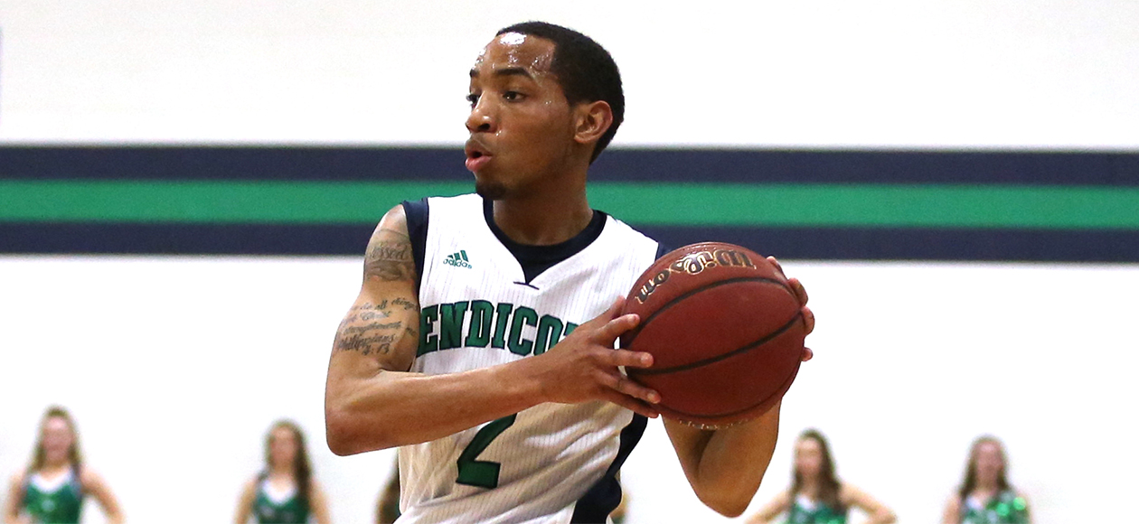 Endicott's senior guard Kamahl Walker holds the ball in his left hand as he looks to right his to pass the ball to a teammate.