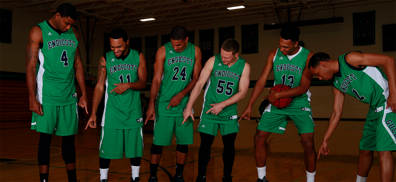 The Endicott men's basketball seniors point to their shoes in a posed photo.