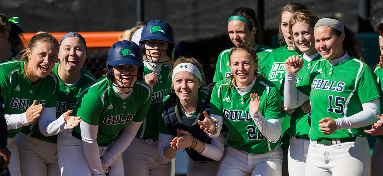 Members of the Endicott softball team wait to congratulate a teammate at home plate. 