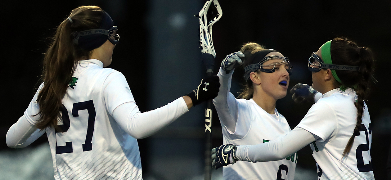 The women's lacrosse team celebrates after a goal.