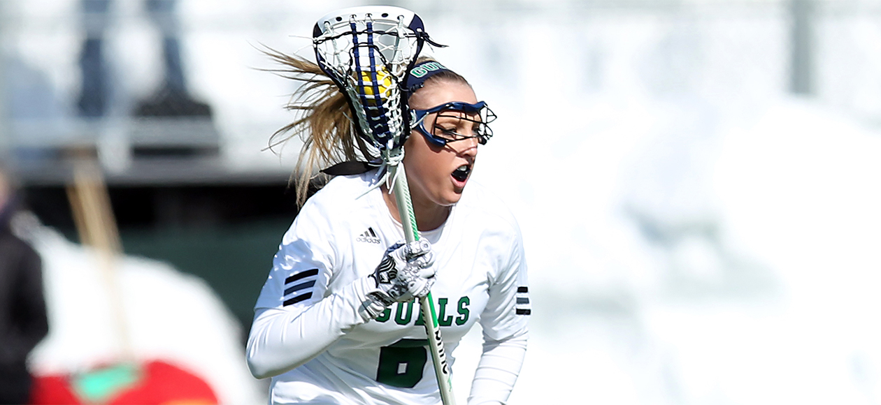 Meghan Lennon cradles the ball in her stick as she runs down the field.