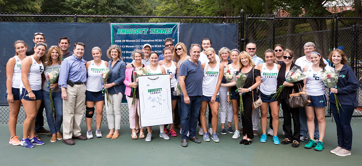 Women's tennis seniors and their families pose for a photo.