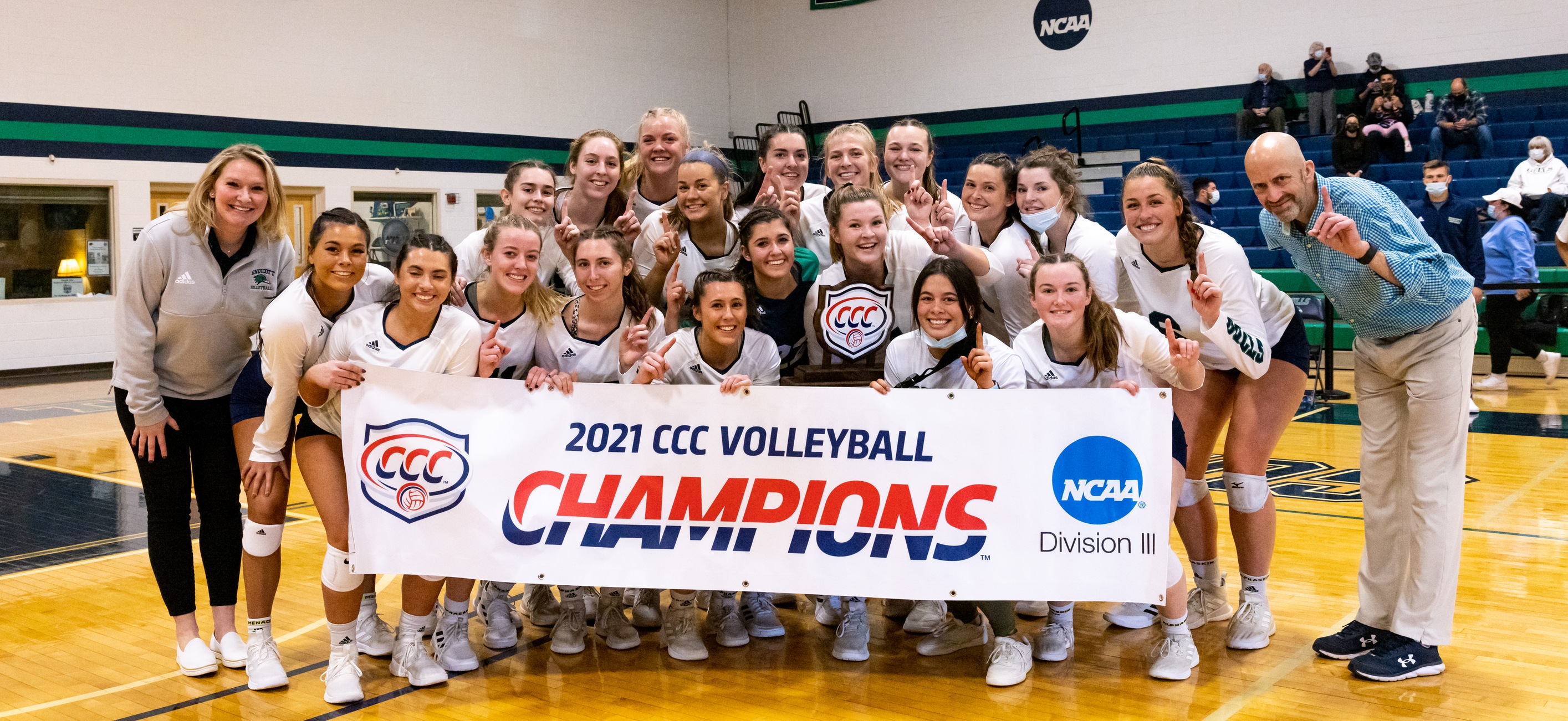 The Endicott women's volleyball student-athletes and coaches pose with the CCC banner and trophy following their 3-1 win over Roger Williams in the 2021 CCC championship.